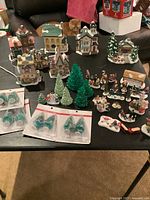 Full view of seven village houses, trees, and many figurines with some accessories