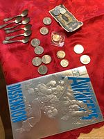 Photo showing all silver teaspoons, assorted Canadian coins, Italian coins, Vietnam currency bill, and comic book.