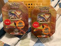 Front view of two sealed Pokémon Diamond & Pearl collector tins, showing front artwork and shrink wrap