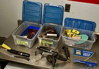 Photo showing three bins: one with 2" buffing discs, one with various sanding and cutting discs, and one with assorted buffing pads alongside three air grinder tools and a box of replacement discs