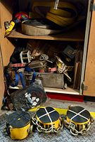 Full view inside cabinet showing multiple rolled straps and metal securing hardware in storage