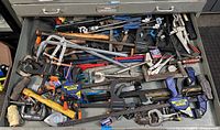 Top-down view of entire toolbox drawer showing mixed clamps, locking pliers and mallet