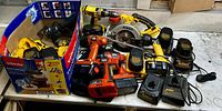 Long shot of the lot showing Dewalt drills, Black & Decker drills, Dewalt circular saw and six chargers