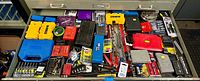 View of the entire content of the toolbox drawer showing a large variety of tool sets, drill bits, sockets, and cases