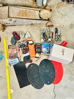 Wide shot of entire lot showing all tools and hardware laid on floor including metal hand tools, testers, gloves, lockbox, and mats