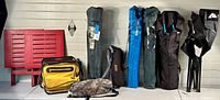 All items displayed side by side including red folding side tables, yellow cooler bag, camouflage bag, six folded lawn chairs in bags of various colors, and a black Beer Store stool.