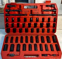 Open red case showing full contents of black impact sockets and accessories