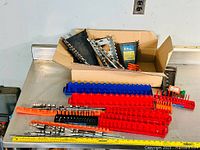 Full view of socket holders arranged on a metal surface with a box in background