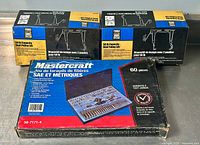 Photo of two boxed dual pulley lift systems and closed Mastercraft tap and die set box