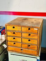 Front view of the 9 drawer wooden cabinet showing the condition and drawer configuration.