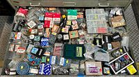Overview photo of large metal drawer filled with assorted screws, nails, and fasteners in original packaging and loose.