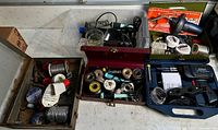 Overview of multiple storage boxes filled with solder equipment including solder wire spools, soldering irons, flux and tools