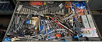 Top-down overview of large toolbox drawer with assorted wrenches and tools scattered inside.