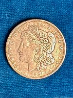 Front side of 1921 Morgan Dollar coin showing Lady Liberty profile with clear text around the circumference.