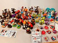 Wide view of all Disney Infinity interactive figurines arranged in rows with cards and power discs in front.