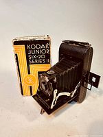 Camera in open folded position with original box behind it