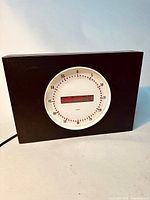 Front view of the Leitch digital analog studio clock showing black case and illuminated circular LED minute markers with digital time display in center.