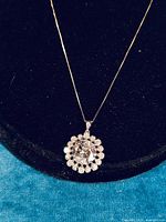 Front view of pendant necklace showing large central CZ stone surrounded by smaller CZ stones