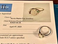 Ring on appraisal certificate showing front view of ring and part of appraisal form with lab logo.