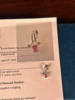 Pendant laid on appraisal paperwork showing design and reference number