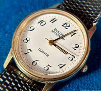 Close-up of white dial showing “Bulova Accutron Quartz,” Arabic numerals and hands