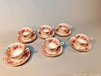 Photo showing all six Royal Albert Serena teacups with their matching saucers arranged on a flat surface.