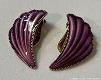Front view of purple scallop shell shaped clip-on earrings with silver beaded edge