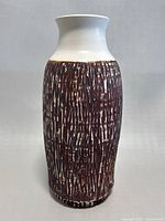 Front view of MCM art pottery vase showing textured dark brown vertical strokes on cream base and smooth off-white neck and mouth.