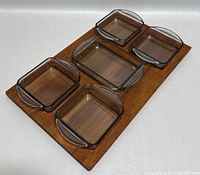 Top angle view showing teak tray with five glass nibble bowls fitting in carved sections