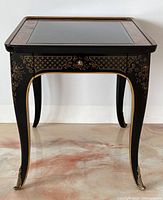Front view of vintage Drexel side table with beveled glass top, Queen Anne legs, and decorative gold designs.