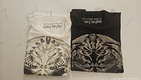 Folded white and black Alexander McQueen x Lane Crawford T-shirts with intricate skull print graphic.