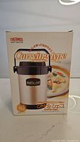 Box front view showing the product name 'Carrying type' by Thermos, with an image of the thermal cooker and a soup bowl.