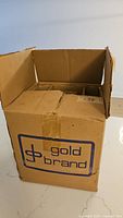 Closed original cardboard box with Gold Brand logo printed on the side, showing general external condition for storage and packaging.