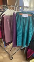 Photo of skirts on display rack with solid and striped patterns in purple and green tones