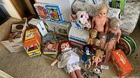 Overview of dolls, books, board games, playsets and accessories on carpet