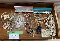 Full tray view of all costume jewelry pieces on wooden surface
