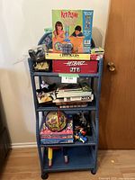 Wicker shelf loaded with multiple board games and toys, positioned next to a wooden door with a brass handle