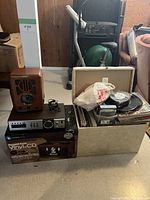 Full lot showing vintage Thomas radio, audio receiver, LP chest filled with records and accessories, and new record player in original packaging.