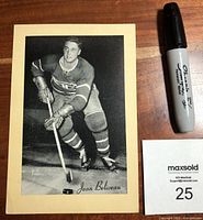 Front view of black and white hockey photograph featuring Jean Beliveau in Montreal Canadiens uniform with printed name.