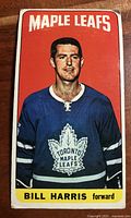 Front side of 1964-65 Topps hockey card featuring Bill Harris in Toronto Maple Leafs jersey on an orange background with yellow name strip
