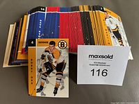 Photo showing a spread of hockey cards including a prominent card of Bobby Orr in a Boston Bruins uniform, card number 4 with defense position indicated in orange and black borders.