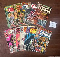 Lot of 10 Marvel Conan The Barbarian comic books ranging from 1973-1986 displayed on wooden floor showing front covers.