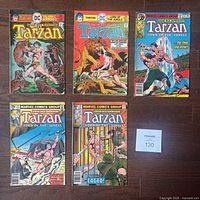 Photo showing five Tarzan comic books from Marvel and DC, featuring vintage covers with jungle and fight scenes.
