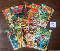 Photo showing all 10 comic books fanned out on a floor, titles and covers visible, showcasing the set included in the lot.