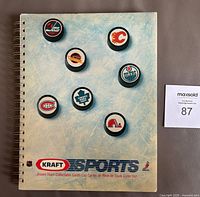 Front cover of 1986-87 Kraft Hockey card album featuring NHL team logos on hockey pucks and Kraft Sports branding.