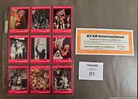 Photo showing full set of 9 Wilt Chamberlain basketball cards arranged in 3 rows with certificate of authenticity to the right, all placed on a dark surface with a MaxSold bidding card.