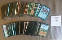 Spread of 163 assorted Magic: The Gathering trading cards showing various card backs and partial front images with diverse colors and art.