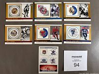 Seven Canada Post NHL All Star Stamp Hockey Cards arranged in two rows with verification card showing stamps and logo patches, and lot number on white paper.