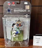 Front view of sealed Marion Barber III McFarlane NFL figurine in Dallas Cowboys uniform, inside original packaging with NFL and Cowboys logos visible.