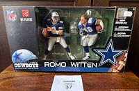 Front view of sealed McFarlane figurine 2-pack featuring Tony Romo and Jason Witten in Dallas Cowboys uniforms inside original box.